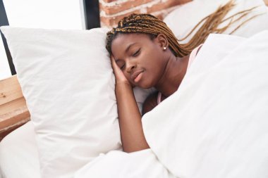 African american woman lying on bed sleeping at bedroom clipart