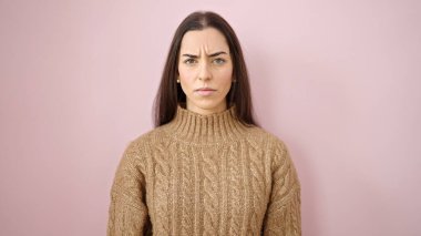 Young beautiful hispanic woman standing with relaxed expression over isolated pink background