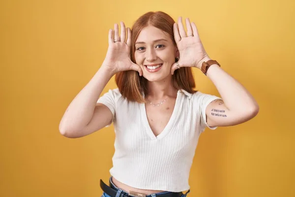 Young Redhead Woman Standing Yellow Background Smiling Cheerful Playing Peek — ストック写真