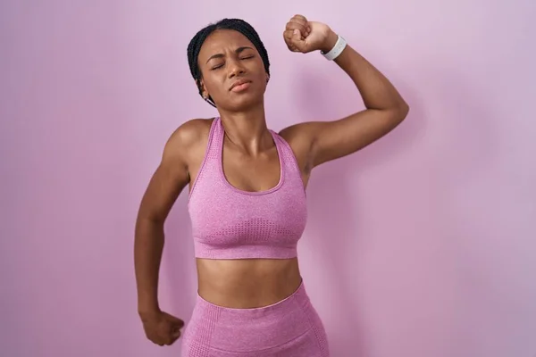 身穿运动服 背景为粉色的非洲裔美国女性 背向后伸展 疲倦而放松 困倦而又打呵欠 直到清早 — 图库照片