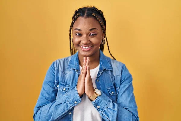 Afroamerikanerin Mit Zöpfen Steht Vor Gelbem Hintergrund Und Betet Mit — Stockfoto
