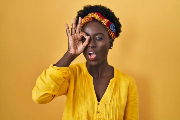 戴着非洲头巾的非洲年轻女子做了个不错的手势 脸上带着惊讶的表情 用手指看了看 不信的表情 — 图库照片