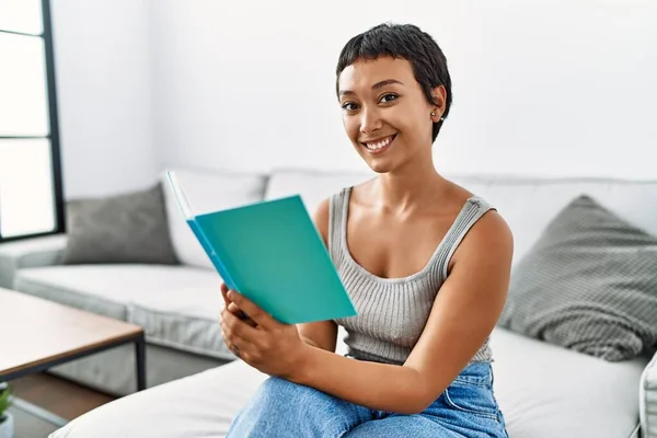 stock image Young hispanic woman smiling confident reading book at home