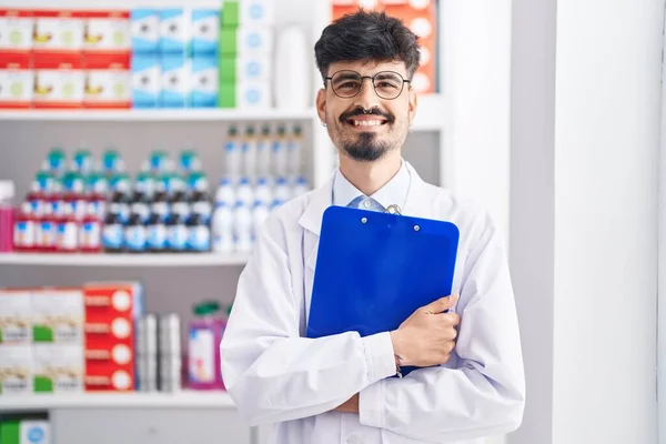 Jonge Spaanse Man Apotheker Glimlachend Zelfverzekerd Klembord Apotheek — Stockfoto