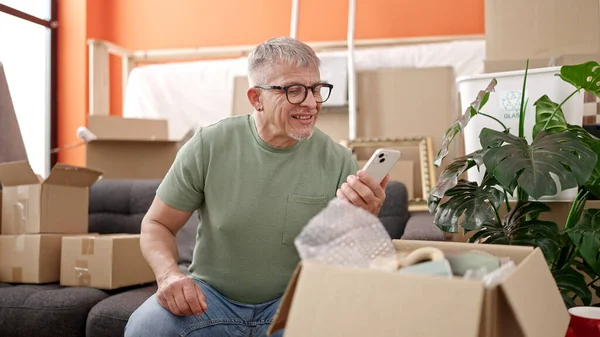 Middle Age Grey Haired Man Unpacking Cardboard Box Using Smartphone — Stock Photo, Image