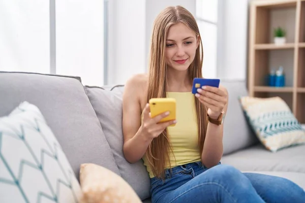 Jovem Caucasiana Usando Smartphone Cartão Crédito Sentado Sofá Casa — Fotografia de Stock