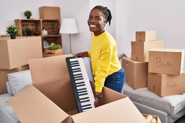 Африканская Американка Улыбается Уверенно Распаковывая Клавиатуру Новом Доме — стоковое фото