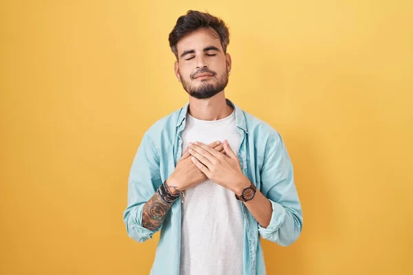 Jovem Hispânico Com Tatuagens Sobre Fundo Amarelo Sorrindo Com Mãos — Fotografia de Stock