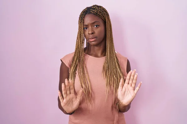Африканская Американка Плетеными Волосами Стоящими Розовом Фоне Отодвигая Ладони Рук — стоковое фото