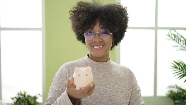 Mladý Afro Americká Žena Usměvavý Jistý Držení Prasátko Banka Doma — Stock fotografie