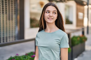 Adorable girl smiling confident looking to the side at street