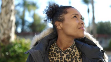 African american woman smiling confident looking to the sky at park
