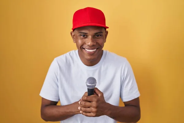 Young Hispanic Man Singing Song Using Microphone Smiling Laughing Hard — Stock Photo, Image
