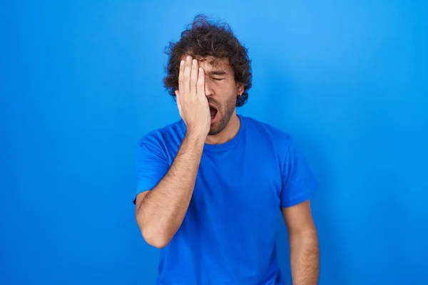 Hispanic Young Man Standing Blue Background Yawning Tired Covering Half — Stockfoto