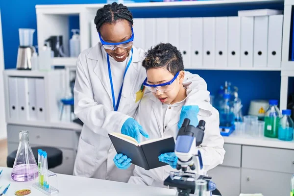 アフリカ系アメリカ人の母親と息子科学者が自信を持って研究室に立ち — ストック写真