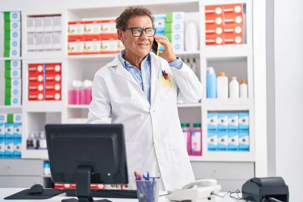 Hombre Mediana Edad Farmacéutico Hablando Teléfono Inteligente Utilizando Ordenador Farmacia — Foto de Stock