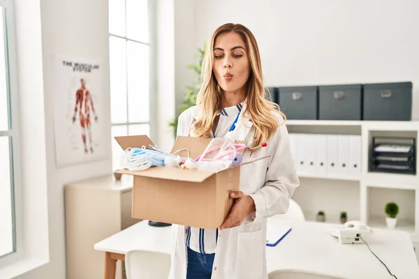 Young Blonde Doctor Woman Holding Box Medical Safety Items Making — Stock Photo, Image