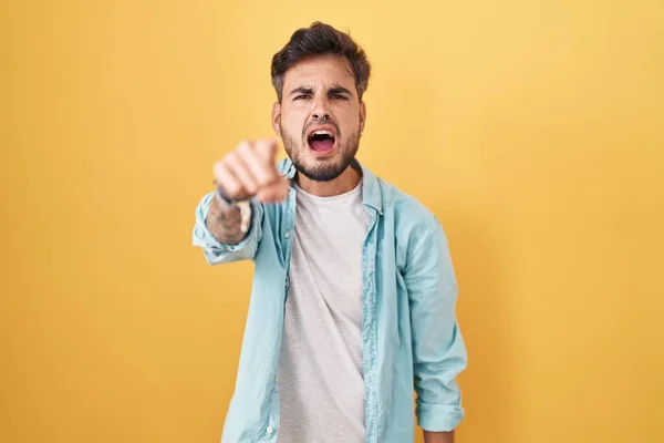Young Hispanic Man Tattoos Standing Yellow Background Pointing Displeased Frustrated — Fotografia de Stock