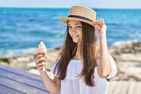 Adorable girl tourist smiling confident eating ice cream at seaside