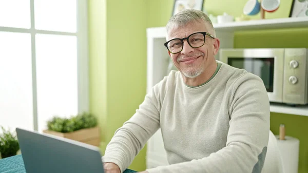Medelålders Gråhårig Man Som Använder Laptop Sittandes Bordet Hemma — Stockfoto