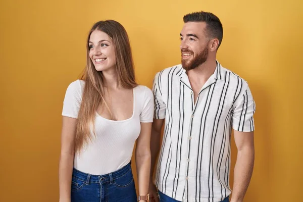 Sarı Arka Planda Duran Genç Bir Çift Yüzünde Gülümseme Doğal — Stok fotoğraf