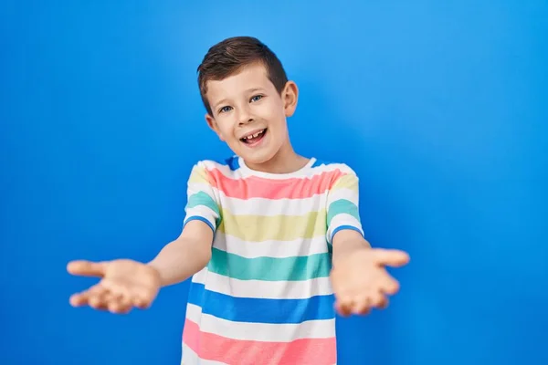 Mavi Arka Planda Duran Genç Beyaz Çocuk Gülümseyerek Yardım Kabullenme — Stok fotoğraf