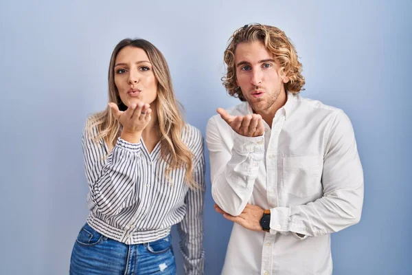 Young Couple Standing Blue Background Looking Camera Blowing Kiss Hand — Stock Photo, Image