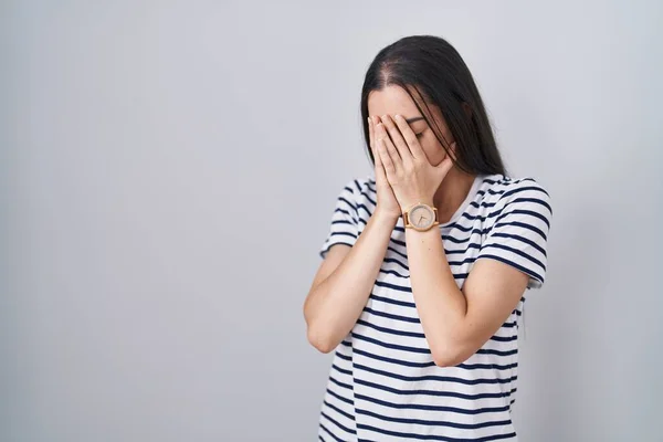 年轻的黑发女人穿着条纹T恤 脸上挂着忧郁的表情 一边哭一边用手捂住脸 抑郁症的概念 — 图库照片