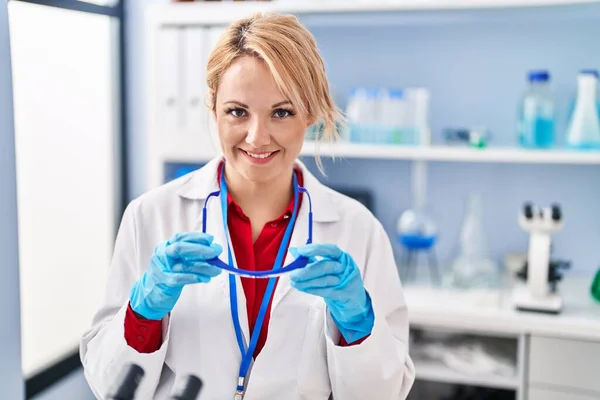 Young Blonde Woman Scientist Smiling Confident Holding Glasses Laboratory — Stock Photo, Image