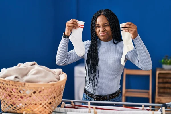 Mujer Afroamericana Sosteniendo Calcetines Escépticos Nerviosos Frunciendo Ceño Molesto Debido —  Fotos de Stock