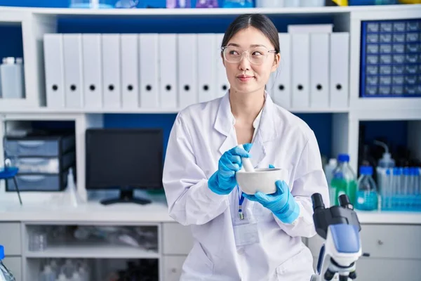 中国年轻女性在实验室工作时 面带微笑地看着旁边 目不转睛地思考着 — 图库照片