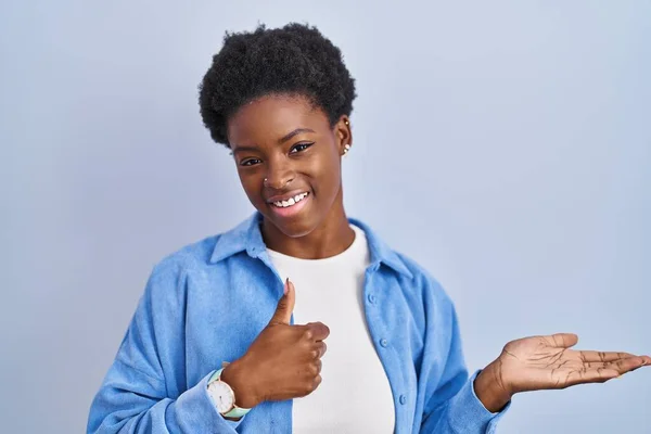 Afričanky Americká Žena Stojící Nad Modrým Pozadím Ukazující Dlaň Ruku — Stock fotografie