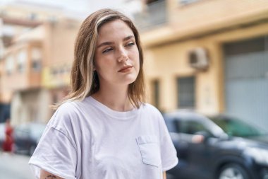 Sokakta duran rahat yüzlü genç kadın.