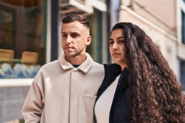 Man and woman couple standing together with relaxed expression at street