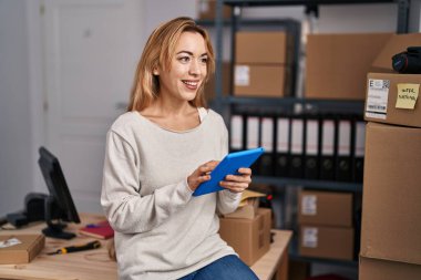 Genç kadın ecommerce busines işçisi ofiste çalışan touchpad kullanıyor.