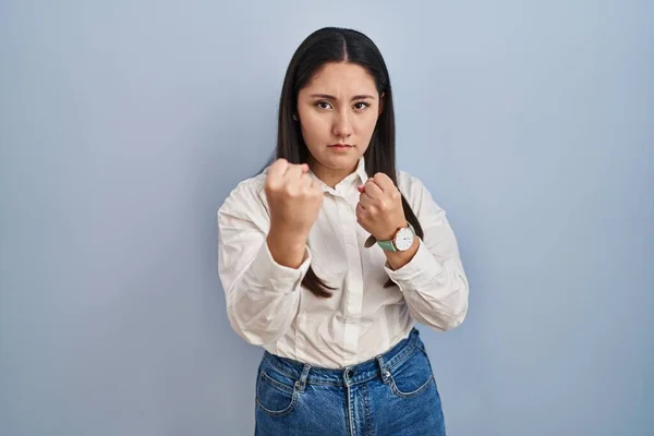 Молодая Латиноамериканка Стоящая Синем Фоне Готовая Драться Кулаком Жестом Защиты — стоковое фото
