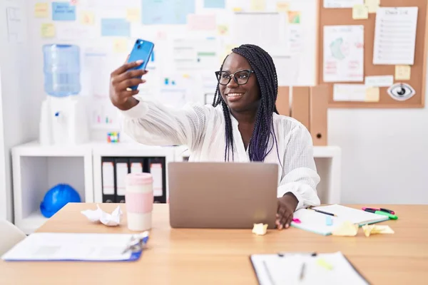 Laptop Kullanan Afrikalı Amerikalı Kadını Ofisteki Akıllı Telefondan Selfie Çekiyor — Stok fotoğraf