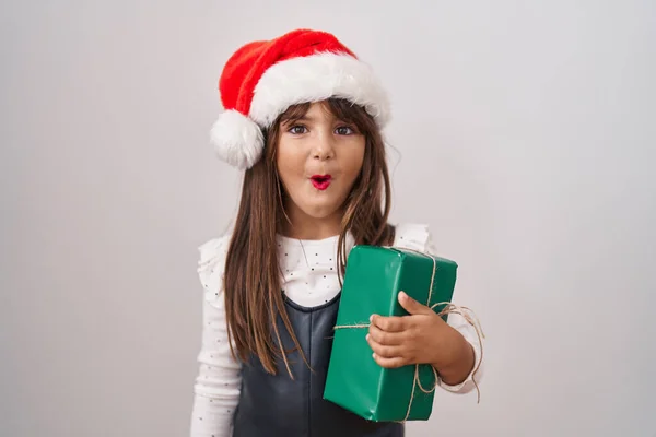 Malá Hispánka Nosí Vánoční Čepici Drží Dárky Vyděšené Ohromený Otevřenými — Stock fotografie