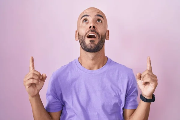 Homem careca de meia-idade segurando uma bola de basquete sobre