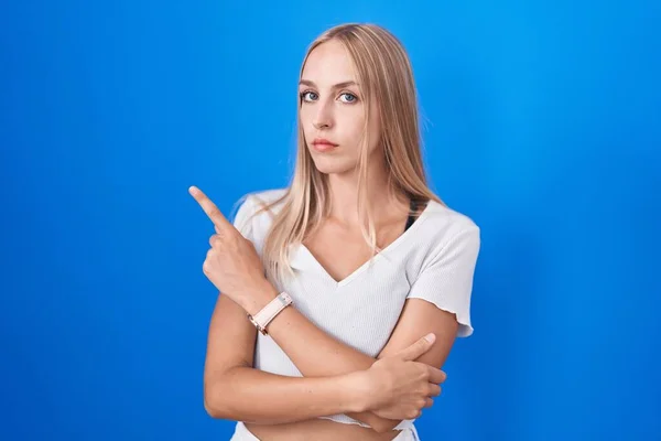 Mujer Joven Caucásica Pie Sobre Fondo Azul Señalando Con Dedo — Foto de Stock
