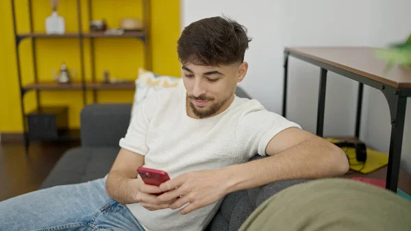 Genç Arap Adam Akıllı Telefon Kullanıyor Evdeki Kanepede Oturuyor — Stok fotoğraf