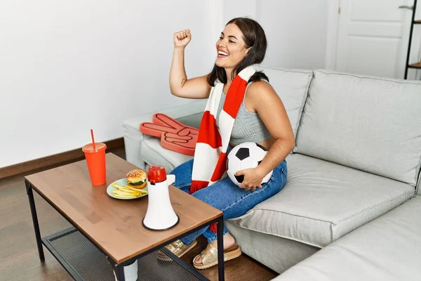 Młoda Piękna Latynoska Kobieta Wspiera Drużynę Piłki Nożnej Siedzącą Kanapie — Zdjęcie stockowe