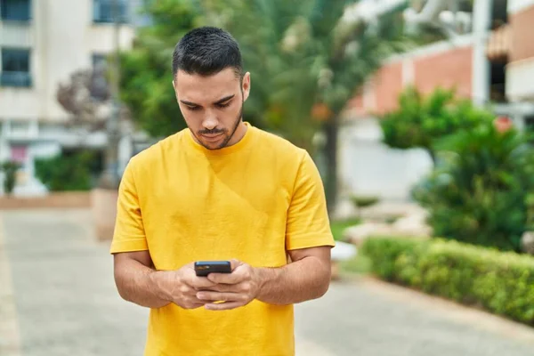 Ung Latinamerikansk Man Använder Smartphone Med Allvarliga Uttryck Parken — Stockfoto