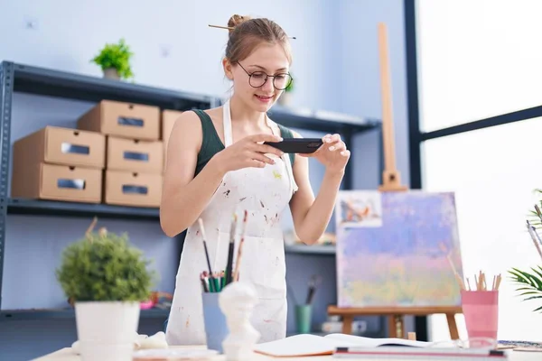 若い白人女性アーティストがアートスタジオで絵を描くために写真を撮る — ストック写真