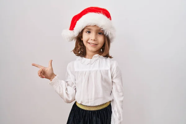 Malá Hispánka Nosí Vánoční Klobouk Veselým Úsměvem Ukazující Rukou Prstem — Stock fotografie