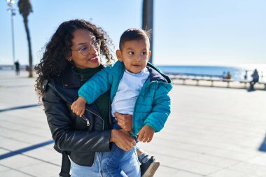 Mother and son hugging each other standing at seaside