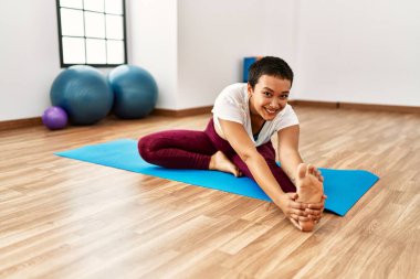 Genç İspanyol kadın gülümsüyor spor merkezinde esniyor.