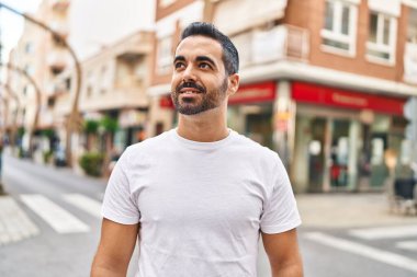 Sokakta kendinden emin gülümseyen İspanyol genç adam.