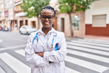 African american woman doctor smiling confident standing with arms crossed gesture at street