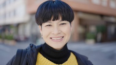 Young chinese woman smiling confident standing at street